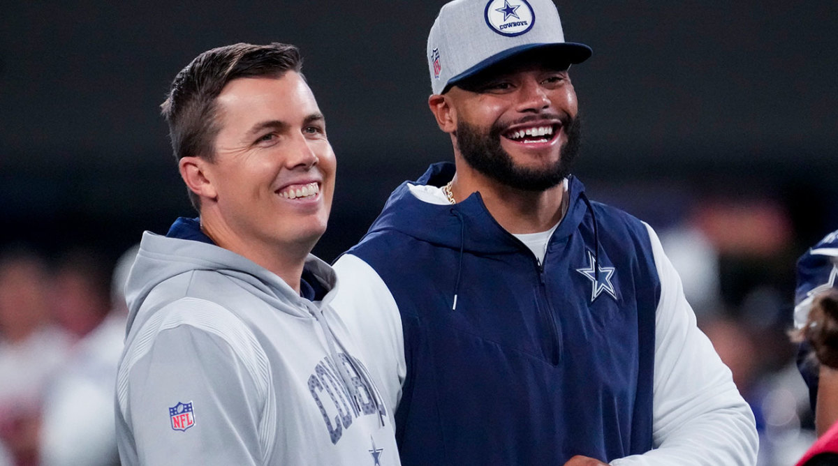 Kellen Moore and Dak Prescott smile on the sideline